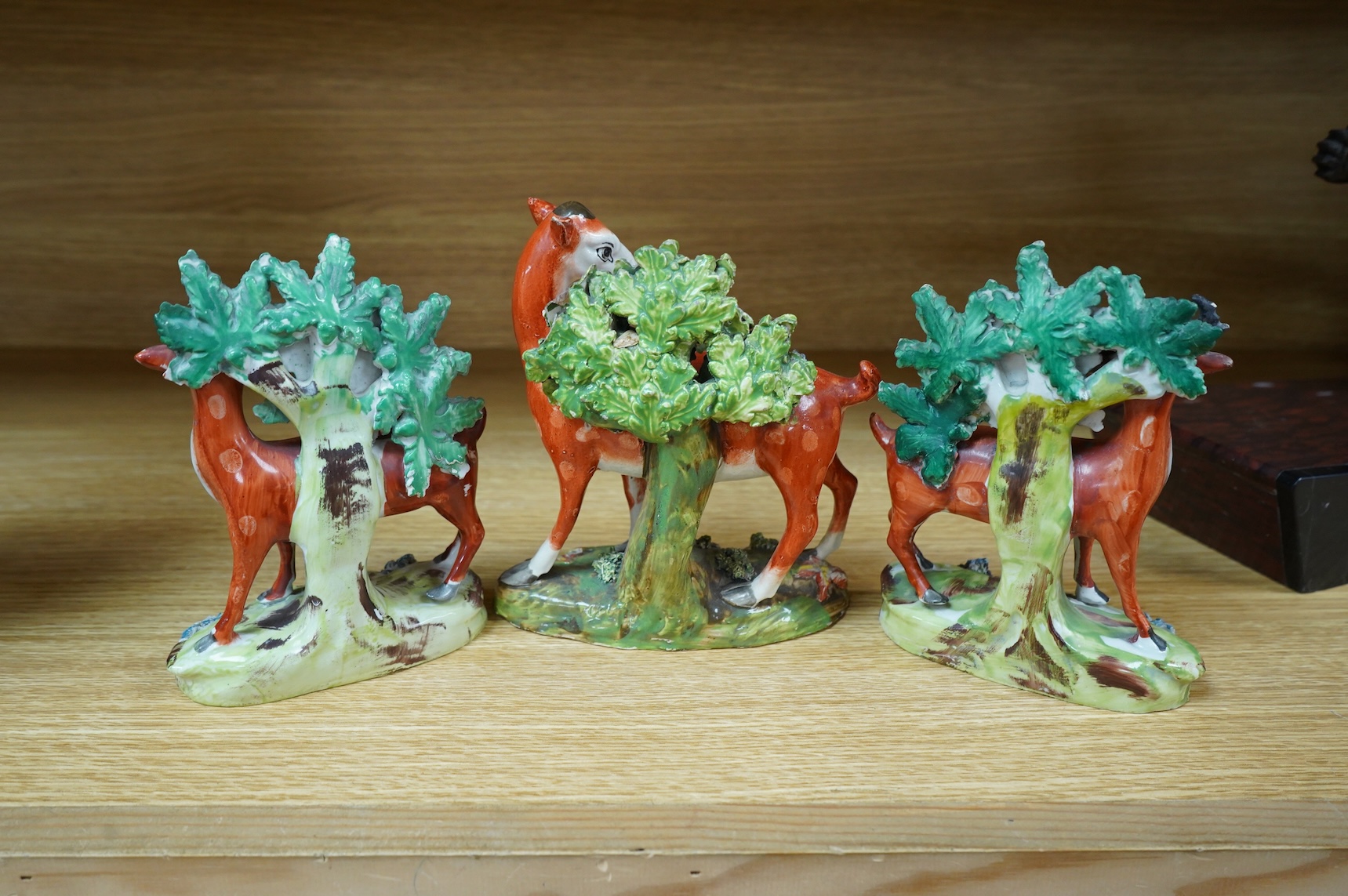 Three early 19th century Staffordshire pottery models of deer, largest 16cm high